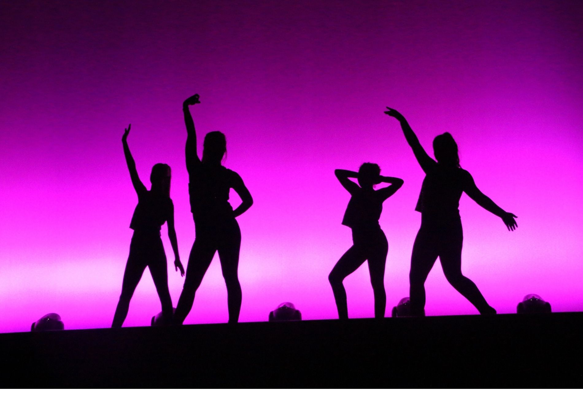 Silhouette of dancers on stage striking poses